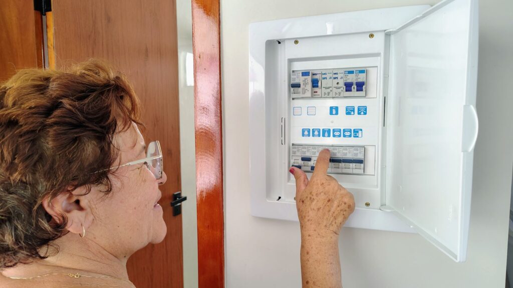 Pessoa conferindo a caixa de luz. Falta de energia elétrica é comum durante a chuva